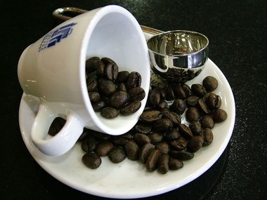 A coffee cup with beans. Photo by Lotus Head via Wikimedia Commons